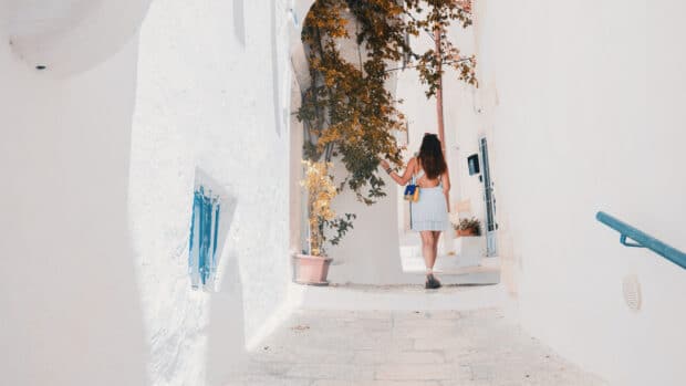 voyageur marchant dans les ruelles blanches de la Grèce