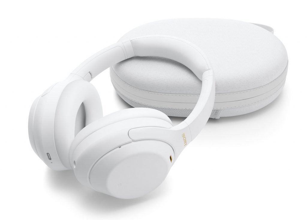 Sony WH1000 XM4 blanc s'appuyant sur son boîtier blanc reposant sur un fond blanc