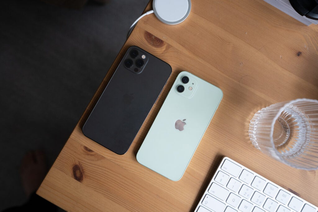 Un iPhone 12 Pro noir et blanc posé à l'envers sur une table en bois, vue de dessus