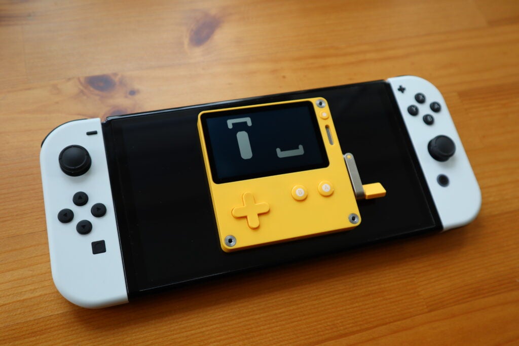 Le Playdate était assis au sommet de la Nintendo Switch OLED