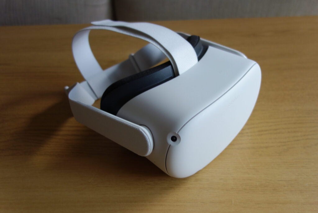 Un Oculus Quest 2 blanc conservé sur une table en bois, vue arrière gauche