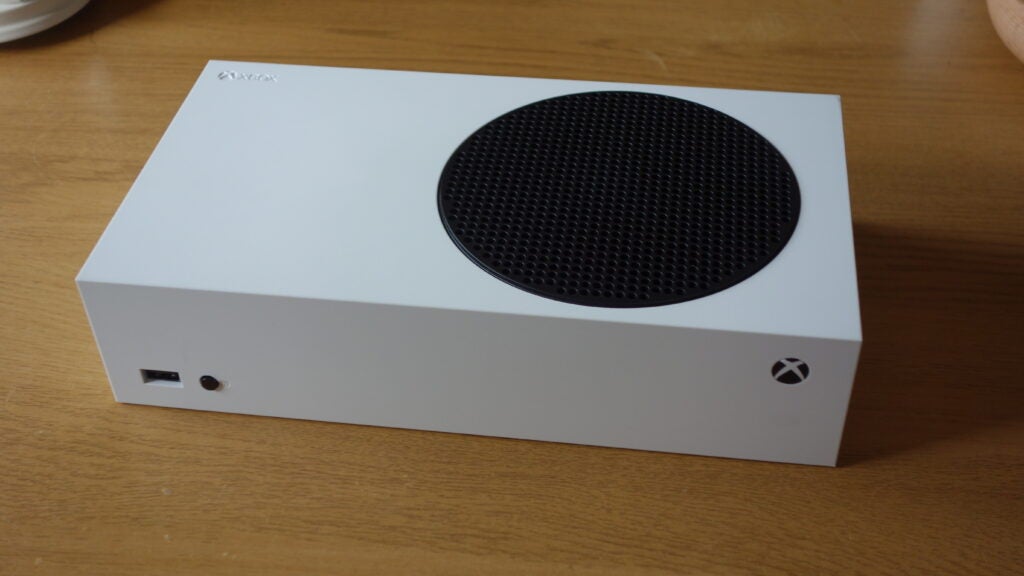 Vue latérale droite d'une Xbox blanche posée sur une table en bois
