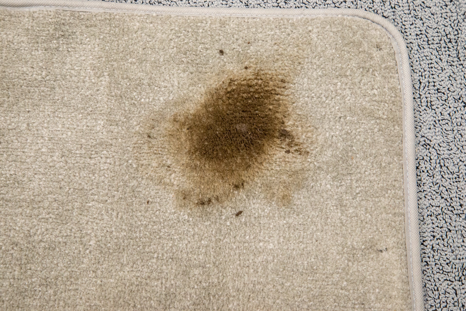 Un tapis sur un tapis avec une tache de saleté brune