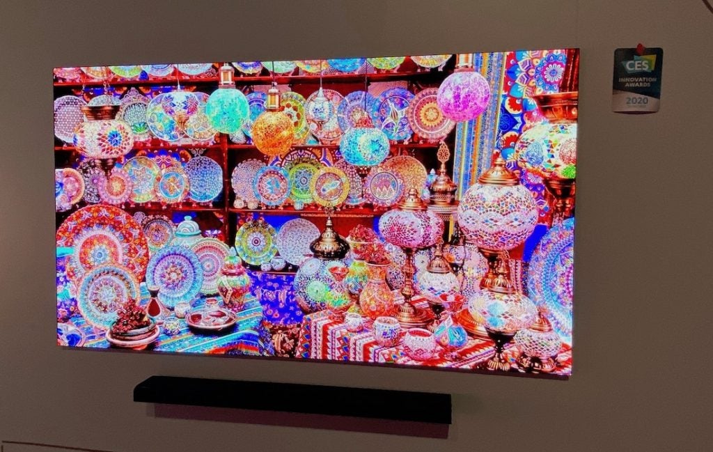 Un téléviseur Samsung 75 Micro LED monté sur un mur affichant une image de vaisselle