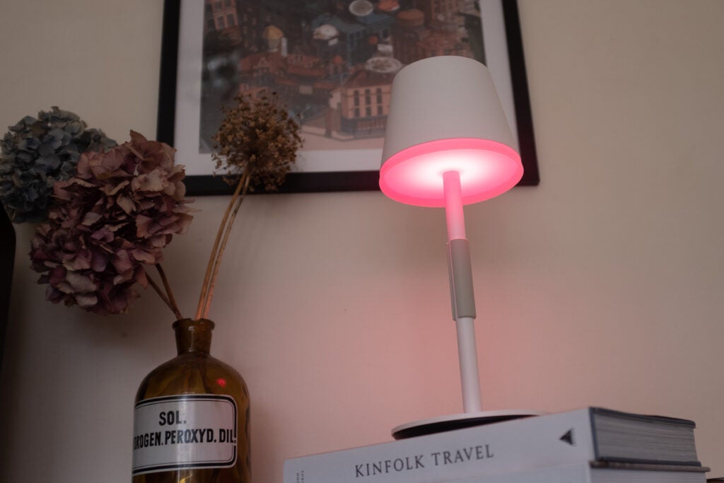 Lampe de table Hue Go avec une lumière rouge sur un angle