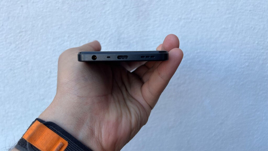 Oppo A78 5G en main montrant le port USB-C et la prise casque 3,5 mm