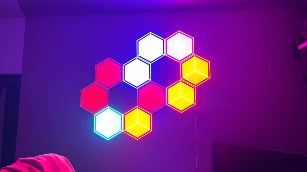 10 panneaux lumineux Govee Glide Hexagon Ultra étant ajustés individuellement pour afficher différentes couleurs à différents niveaux de luminosité. 