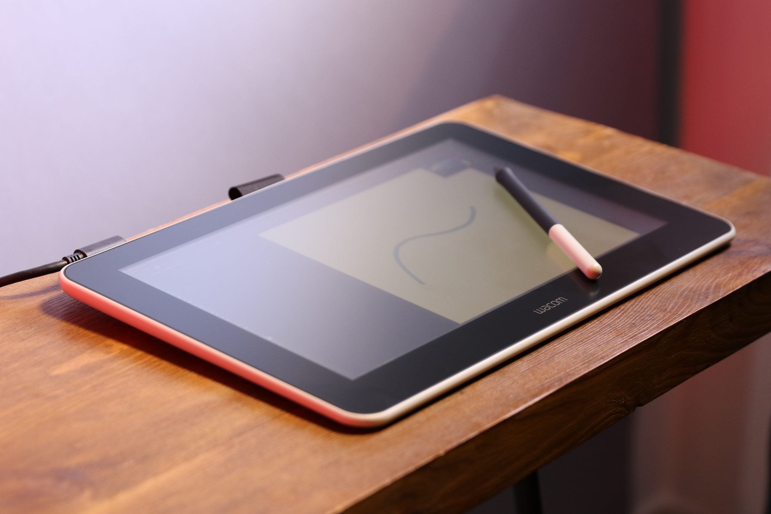 Une tablette Wacom avec son stylet posé sur une table en bois