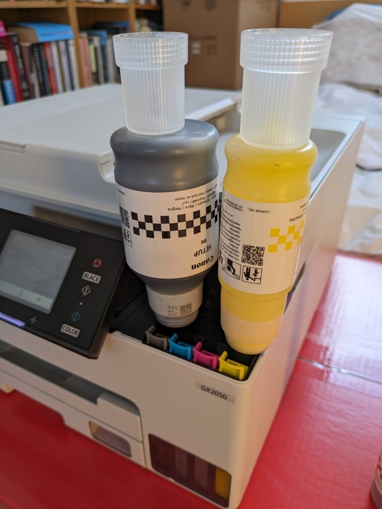 Bouteilles d'encre noire et jaune remplissant l'imprimante