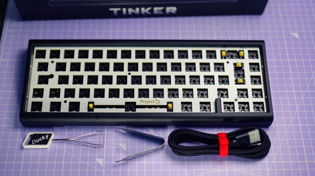 Clavier Ducky ProjectD Tinker 65 Barebones sur bureau avec accessoires.